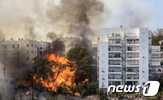 본문 이미지 - 24일(현지시간) 이스라엘 하이파에서 화염이 높이 치솟아 아파트를 위협하고 잇다. ⓒ AFP=뉴스1