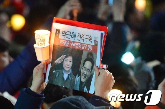 본문 이미지 - 26일 밤 서울 종로구 정부서울청사 창성동 별관 인근에서 5차 촛불집회에 참여한 시민들이 행진 중 경찰차벽에 가로막히자 촛불을 들고 농성을 벌이고 있다. 2016.11.26/뉴스1 ⓒ News1 신웅수 기자