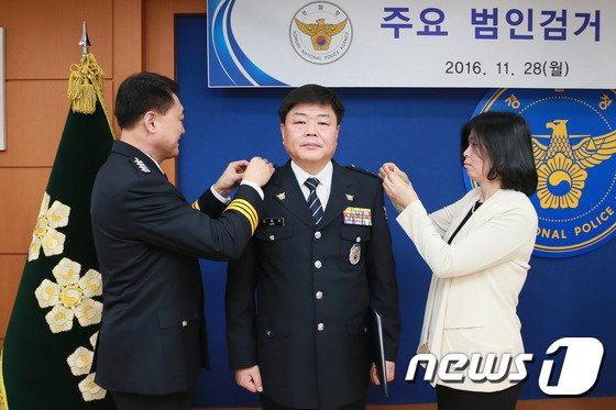 본문 이미지 - 2016년 11월 28일 이철성 경찰청장이 서울 서대문구 경찰청에서 열린 '주요 범인검거 특별승진 임용식'에서 18년 전인 1998년 서울 노원에서 발생한 가정주부 살해사건 범인을 검거한 유공경찰관 김응희 경감(경위에서 1계급 특진)에게 계급장을 달아주고 있다. (경찰청 제공) 2016.11.28/뉴스1