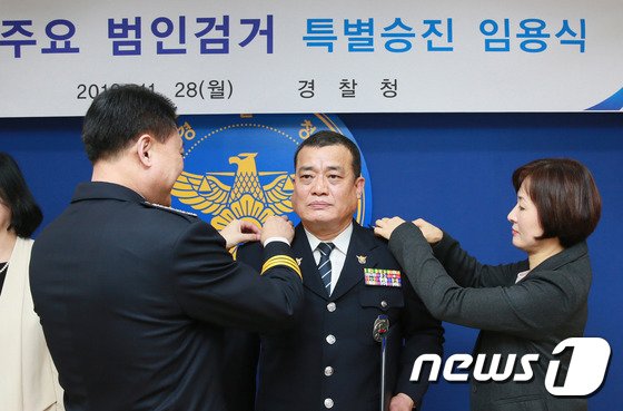 본문 이미지 - 이철성 경찰청장이 28일 서울 서대문구 경찰청에서 열린 '주요 범인검거 특별승진 임용식'에서 15년 전 2001년 경기도 용인에서 발생한 교수 부인 살해사건 범인을 검거한 유공경찰관 박장호 경감에게 표창을 수여하고 있다.  2016.11.28/뉴스1