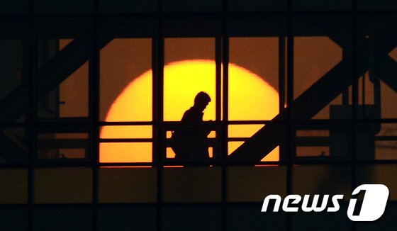 본문 이미지 - 정부세종청사 창문 뒤로 태양이 저물어가고 있다. (자료사진) /뉴스1 ⓒ News1 장수영 기자