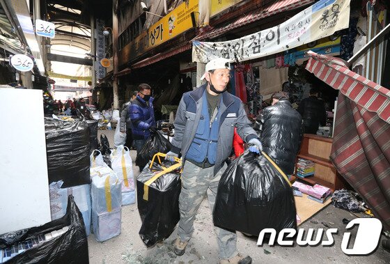 본문 이미지 - 4일 대구 서문시장에서 상인들이 점포 내 불에 타지 않은 물건들을 챙겨서 나오고 있다. 대구시 중구청은 지난 달 30일 불이 난 서문시장 4지구 1층에 있는 점포 84개 소에 대해 상인들의 출입을 허용했다. 중구청은 물건정리가 끝나면 상인들과 인근 시민들의 통행안전을 위해 화재현장 주변에 높이 2.4m,길이 260m의 펜스를 설치할 계획이다.(대구시 중구청제공)2016.12.4/뉴스1 ⓒ News1 정지훈 기자