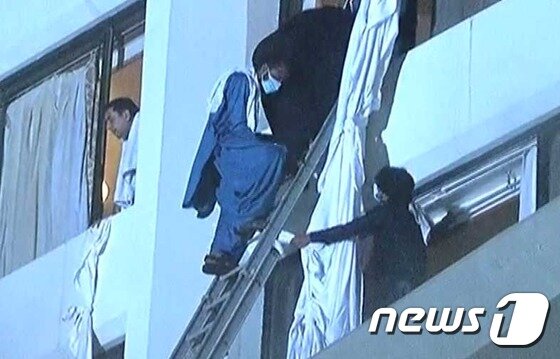 본문 이미지 - 5일(현지시간) 오전 파키스탄 항구 도시 카라치의 4성급 호텔에서 대형 화재가 발생해 승객들이 이불과 옷가지를 연결해 창문 밖으로 탈출하고 있다. 이 화재로 최소 11명이 숨지고 70명이 다쳤다. (현지 방송 갈무리) ⓒ News1