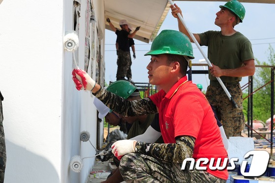 (방콕=뉴스1) = 인도적 차원의 다국적 연합훈련인 2016 코브라골드 훈련에 참가한 해군·해병대 장병들이태국 잔타부리 왓쿤송 학교에서 도서관 건물 외부 도색 작업을 하고 있다. …