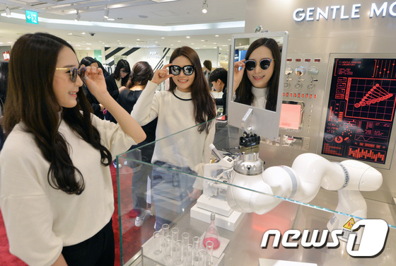(서울=뉴스1) 송원영 기자 = 10일 서울 롯데백화점 본점 '더 웨이브' 팝업스토어 매장에서 고객들이 젠틀몬스터 로봇 '쿠카'의 도움을 받아 선글라스를 착용하고 있다. 젠틀몬스터 …