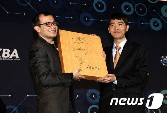 본문 이미지 - 이세돌 9단이 15일 오후 인공지능 알파고와의 ‘구글 딥마인드 챌린지 매치’ 5번기 제5국을 마친 뒤 서울 광화문 포시즌스호텔에서 데미스 하사비스 구글 딥마인드 대표에게 바둑판에 사인을 해서 선물을 하고 있다. 2016.3.15 ⓒ 뉴스1 송원영 기자