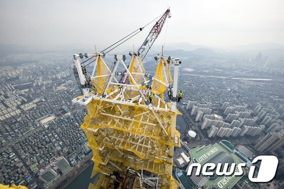 본문 이미지 - 국내 최대 64톤급 타워크레인을 활용한 롯데월드타워 최상층부 다이아그리드 랜턴 설치 작업 모습 ⓒ News1
