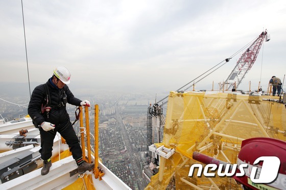 (서울=뉴스1) 이광호 기자 = 17일 오후 롯데월드타워가 최상층부 첨탑 구조물 공사를 마치고 국내 최고 높이인 555m에 도달했다.공사 현장에서 인부들이 작업을 하고 있다. 20 …
