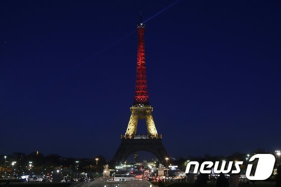 본문 이미지 - 22일(현지시간) 브뤼셀 테러로 희생된 이들을 추모하며 벨기에 국기를 상징하는 검정·노랑·빨강 조명으로 물든 파리 에펠탑. ⓒ AFP=뉴스1