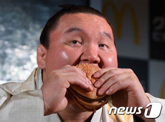 (도쿄 AFP=뉴스1) 최종일 기자 = 몽골 출신으로 일본 스모에서 요코즈나(橫網)에 오른 하쿠호(白鵬)가 31일 도쿄에서 열린 일본 맥도날드 홍보 행사에서 햄버거를 먹고 있다.ⓒ …