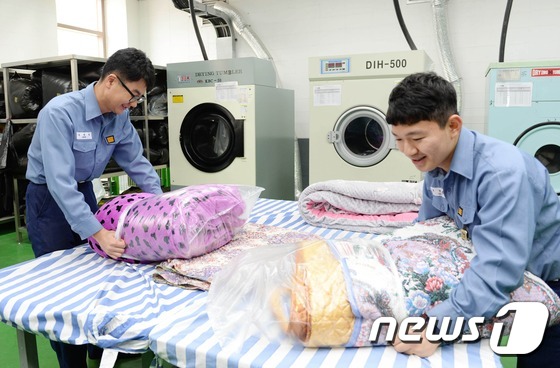 (서울=뉴스1) 조현아  인턴기자 = 가정의 달을 이틀 앞둔 29일 해군 1함대 보급지원대대 정대현 병장(왼쪽)과 조현성 상병이 부대 세탁실에서 깨끗하게 세탁된 이불을 비닐로 포장 …