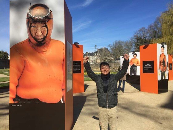 본문 이미지 - 세계인의 시선을 받고 있는 김형선 사진작가가 프랑스 해녀 전시장에서 포즈를 취하고 있다.ⓒ News1star / 강공컴퍼니