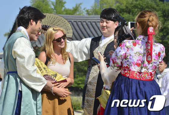 (서울=뉴스1) 신웅수 기자 = 화창한 날씨를 이어진 13일 오후 서울 경복궁에서 대학생들이 외국인에게 부채로 바람을 부쳐주며 대화를 하고 있다. 2016.5.13/뉴스1