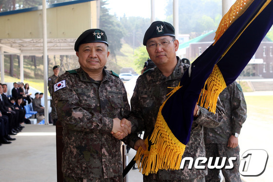 (삼척=뉴스1) 서근영 기자 = 2일 육군 제23보병사단 사령부 대연병장에서 열린 24·25대 사단장 이취임식에서 박한기 제8군단장(왼쪽)이 김한태 신임 23사단장에게 부대기를 건 …