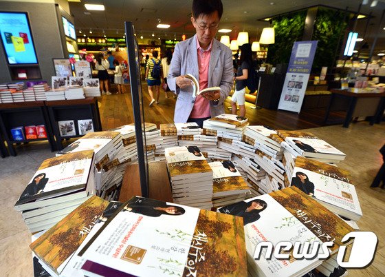 본문 이미지 - 한강의 '채식주의자'가 교보문고 소설부문 베스트 셀러 1위로 오른 22일 오전 서울 종로구 세종로 교보문고 광화문점에서 시민들이 채식주의자를 읽고 있다. ⓒ News1 최현규 기자