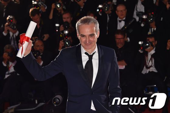 (칸 AFP=뉴스1) 우동명 기자 = 올리비야 아사야스 감독이  22일 (현지시간) 제69회 칸 국제영화제 포토콜에서  감독상을 받은 뒤 포즈를 취하고 있다.ⓒ AFP=뉴스1