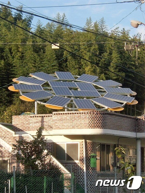 본문 이미지 - 전남 순천시 도사동 야흥 햇빛마을의 한 주택에 설치된 해바라기 모양의 태양광 발전설비가 에너지 자립마을임을 상징하고 있다.(순천시 제공)2016.5.24/뉴스1 ⓒ News1 지정운 기자