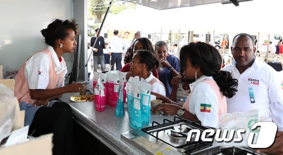 (서울=뉴스1) = 코리아에이드 출범식이 열린 28일 오전(현지시간) 한국에서 온 자원봉사자들이 에티오피아 어린이에게 한국의 쌀과자를 간식으로 주고있다. 리아에이드 출범식이 열린 …