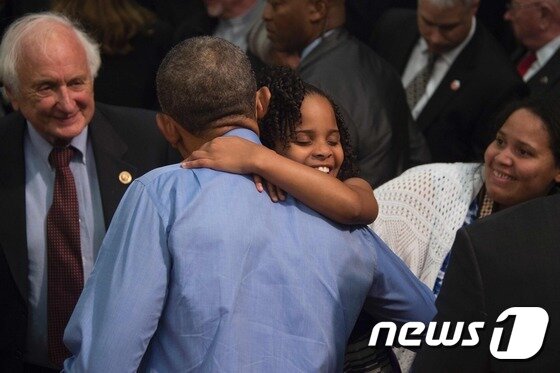 본문 이미지 - 4일(현지시간) 버락 오바마 미국 대통령이 자신에게 편지를 보내 대통령의 방문을 요청한 마리 코페니를 안아 주고 있다. ⓒ AFP=뉴스1