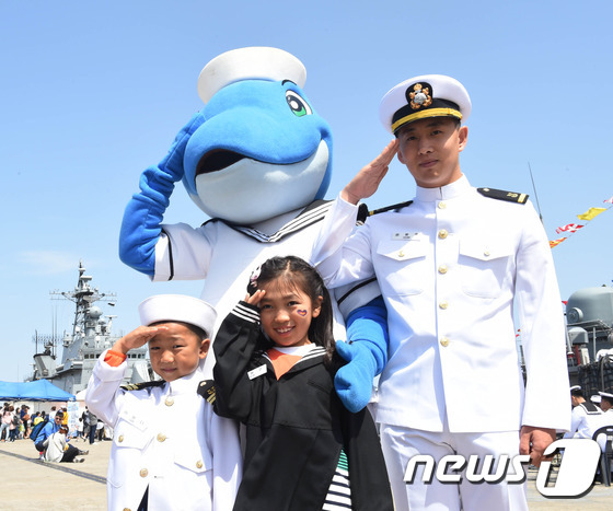(동해=뉴스1) 서근영 기자 = 어린이날인 5일 강원 동해시 동해 군항에서 열린 함정 공개 행사에서 어린이들이 해군 마스코트인 해돌이와 해군 장병과 함께 경례하고 있다. (해군 1 …