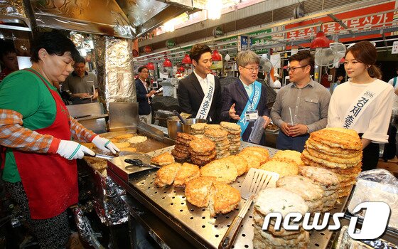 본문 이미지 - 유경준 통계청장과 홍보대사 박선영 아나운서, 배우 지진희가 12일 오전 서울 종로구 광장시장 을 찾아 상인에게 2016 경제총조사 방문면접 참여를 독려하고 있다. 2016.6.12/뉴스1 ⓒ News1 안은나 기자