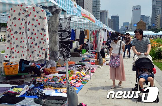 본문 이미지 - 서울 광화문광장에서 열린 '2016 광화문 희망나눔장터'에서 시민들이 판매하는 물품을 보며 걷고 있다.  2016.6.19/뉴스1 ⓒ News1 최현규 기자