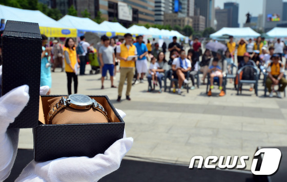 (서울=뉴스1) 최현규 기자 = 19일 오후 서울 광화문광장에서 열린 '서울시, 에너지 나눔 옥션 홍보대사 기증 애장품 경매'에서 시민들이 입찰을 하고 있다. '2016 광화문 희 …