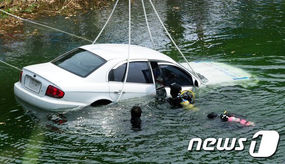 본문 이미지 - 21일 전북 김제시 백구면 담수호에서 실시한 수중 시체 및 증거물의 압수시점 추정 연구실험에서 전북지방경찰청 관계자들이 돼지사체가 들어있는 차량을 담수호에 넣고 있다.2016.6.21/뉴스1 ⓒ News1 문요한 기자