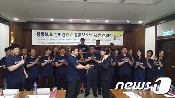 본문 이미지 - 24일 서울 여의도 국회 도서관 소회의실에서 열린 '동물보호 콘퍼런스&동물보호법 개정 건의식'에서 김재영 한국고양이수의사회 회장이 한정애 의원에게 동물보호법 개정 건의안을 전달하고 있다.ⓒ News1