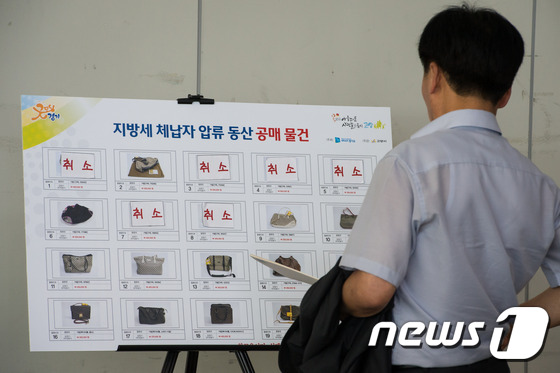 (고양=뉴스1) 유승관 기자 = 9일 경기 고양시 킨텍스 제1전시장 그랜드볼룸에서 열린 지방세 체납자 압류 동산 공매에 참여한 한 입찰자가 공개매각에 나온 명품가방, 귀금속 등의 …