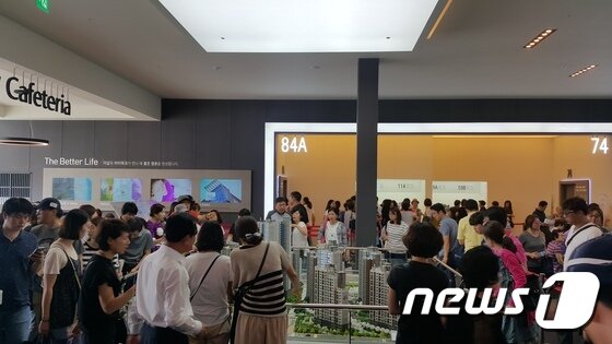 본문 이미지 - 평촌 더샵 아이파크 모델하우스를 방문한 이들이 단지 모형을 살펴보며 설명을 듣고 있다. ⓒ News1