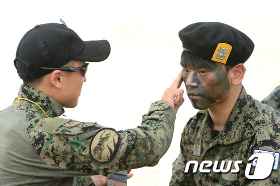 (이천=뉴스1) 임세영 기자 = 19일 오전 경기도 이천시 마장면 제3공수특전여단에서 열린 탈북 청소년 병영캠프에서 교관이 탈북 청소년 얼굴에 위장크림을 발라주고 있다. 2016. …
