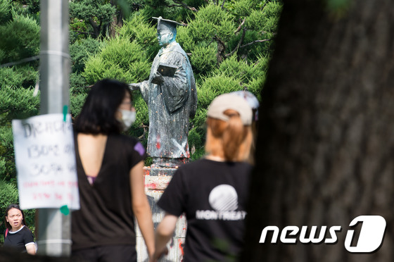 (서울=뉴스1) 유승관 기자 = 31일 서울 서대문구 이화여자대학교 본관 앞에서 학생들이 훼손된 초대총장 김활란 박사 동상 앞을 지나고 있다. 이화여대 학생들은 교육부의 \'평생교 …