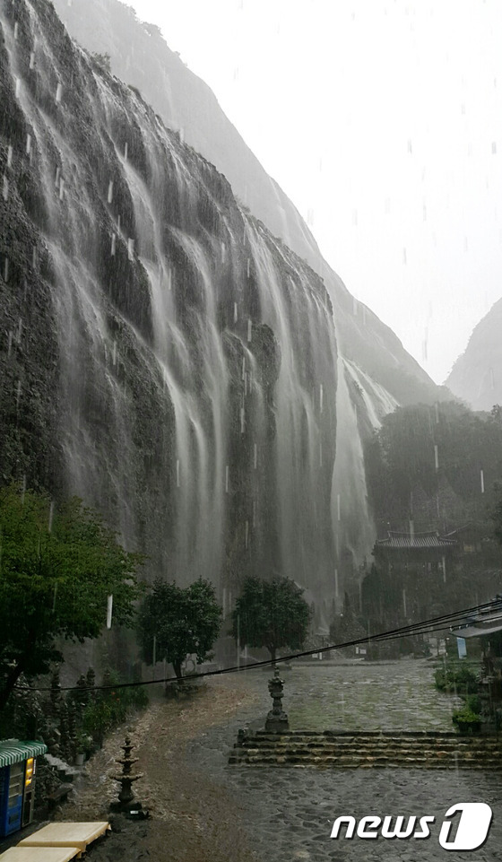 (진안=뉴스1) 문요한 기자 = 5일 전북 진안군 마이산 탑사 주변 암벽에 최근 내린 장맛비가 쏟아지며 폭포의 모습을 보이고 있다. 이 폭포는 매년 장마철에만 모습을 볼 수 있으며 …