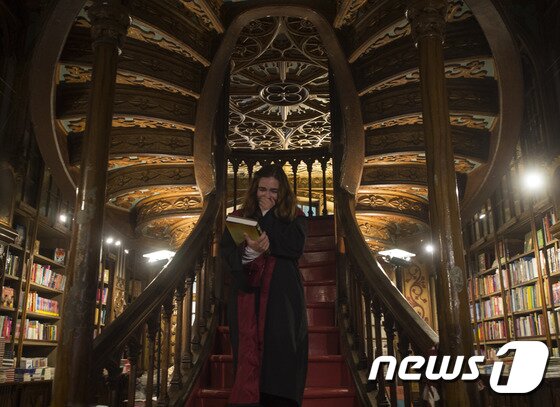 본문 이미지 - 31일(현지시간) 포르투갈 한 서점가에서 '해리포터와 저주받은 아이'를 첫 구매한 소녀가 기념사진을 찍고 있다. ⓒ AFP=뉴스1