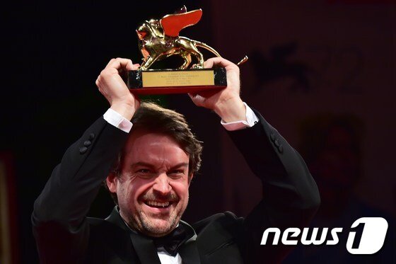본문 이미지 - 지난해 열린 제 72회 베니스 국제 영화제에서 황금 사자상을 수상한 '먼 곳으로부터'의 감독 로렌조 비가스가 세리모니를 하고 있다. ⓒ AFP=뉴스1