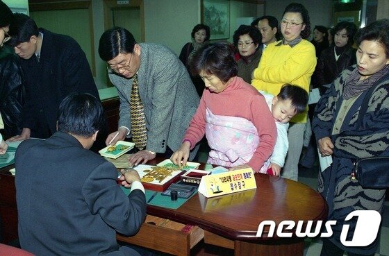 본문 이미지 - 행정자치부 국가기록원이 공개한 '1998년 나라사랑 금모으기 운동에 참여한 시민' 모습. 국가기록원은 우리나라의 IMF 및 IBRD 가입일을 맞아 8월 이달의 기록 주제를 '우리나라의 경제 성장을 지원한 국제금융기구(IMF, IBRD), 기록으로 보다'로 정하고 관련 기록물을 오는 23일부터 누리집을 통해 서비스한다. (국가기록원 제공) 2016.8.22/뉴스1 ⓒ News1 추연화 기자