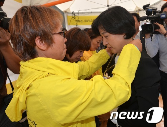 (서울=뉴스1) 박지혜 기자 = 29일 오후 서울 종로구 광화문광장 세월호 유가족 단식 농성장을 찾은 추미애 더불어민주당 대표에게 한 유가족이 목걸이를 걸어주고 있다. 2016. …