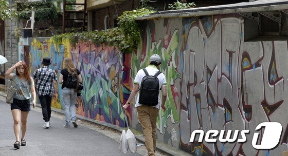 본문 이미지 - 30일 오후 서울 마포구 홍익대 인근에서 열린 2016 제24회 홍대 앞 거리미술전에서 시민들이 그라피티 앞을 지나고 있다. 2016.8.30/뉴스1 ⓒ News1 안은나 기자