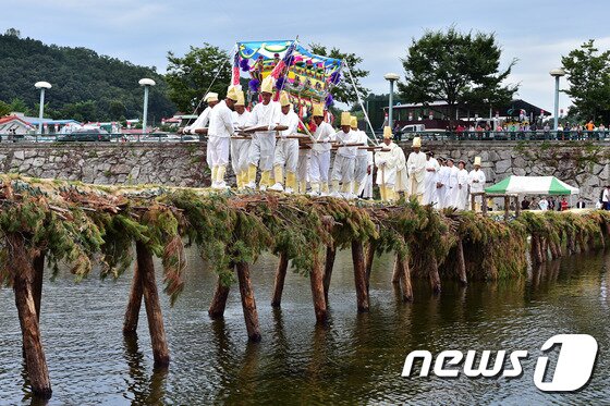 본문 이미지 - 1일 '제20회 무주반딧불축제' 메인프로그램 중 하나인 전통섶다리 공연이 전북 무주군 남대천 섶다리에서 펼쳐지고 있다. 전통섶다리 공연은 주민들이 통나무와 솔가지를 이용해 직접 설치한 섶다리 위에서 전통혼례와 농악놀이, 상여 행렬 등 잊히는 옛 문화를 재연하는 것이다. /뉴스1 DBⓒ News1