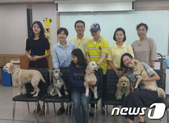 본문 이미지 - 10일 김광식 원장(왼쪽에서 세 번째) 이 사회화교육을 마친 뒤 기념촬영을 하고 있다. 앞줄의 왼쪽에서 세 번째 개가 1등을 차지한 로빈. ⓒ News1