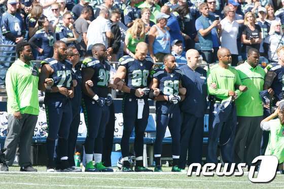 본문 이미지 - 시애틀 시호크스 선수들이 11일(현지시간) 센츄리링크필드 경기장에서 국민의례 도중 서로의 팔을 가슴에 포개 잡고 있다. ⓒ AFP=뉴스1