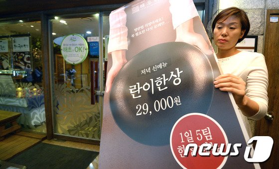 본문 이미지 - 부정청탁 및 금품등 수수의 금지에 관한 법률(일명 김영란법) 시행을 하루 앞둔 27일 서울 중구의 한 식당에서 직원이 '란이한상' 메뉴를 소개하는 배너를 설치하고 있다. . 2016.9.27/뉴스1 ⓒ News1 황기선 기자