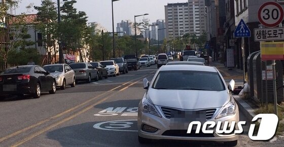 본문 이미지 - 보행자 안전을 위해 생활도로구역으로 지정됐다는 안내표시가 무색할 정도로 도로 양 옆에 불법주정차가 만연해 있다 ⓒ News1 이인희 기자