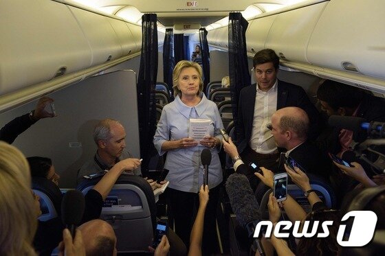 본문 이미지 - 힐러리 클린턴 민주당 대선후보가 5일(현지시간) 전용기 안에서 기자들과 인사를 나누고 있다. ⓒ AFP=뉴스1