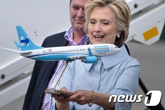 본문 이미지 - 힐러리 클린턴 민주당 대선후보가 5일(현지시간) 미국 뉴욕 웨스트체스터카운티 공항에서 자신의 전용기 '힐포스원'의 모형을 들고 있다. ⓒ AFP=뉴스1