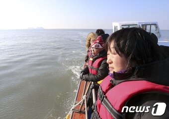 본문 이미지 - 새해 첫 날인 1일 오전 세월호 유가족들이 전남 진도군 세월호 참사 해역을 방문해 세월호 인양작업을 하고 있는 상하이 샐비지 바지선을 바라보고 있다. 2017.1.1/뉴스1 ⓒ News1 신채린 기자