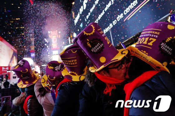 본문 이미지 - 2016년 12월 31일(현지시간) 새해맞이 행사가 열리고 있는 미국 뉴욕 타임스퀘어에서 커플이 키스하고 있다. ⓒ AFP=뉴스1 ⓒ News1 최종일 기자