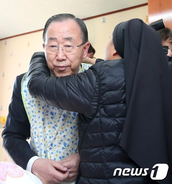 본문 이미지 - 반기문 전 유엔 사무총장이 14일 오후 충북 음성군 맹동면에 위치한 사회복지시설 꽃동네를 찾아 요양 중인 할머니에게 수발봉사를 하기 전 앞가리개를 하고 있다. 2017.1.14/뉴스1 ⓒ News1 구윤성 기자