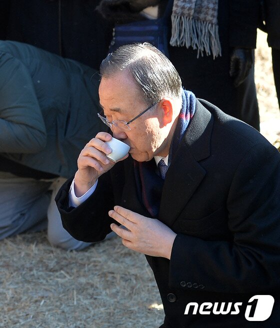 본문 이미지 - 반기문 전 유엔사무총장이 지난 14일 오전 고향인 충북 음성군 원남면 행치마을을 방문해 선친의 묘에 성묘한 뒤 음복하고 있다. 2017.1.14/뉴스1 ⓒ News1 구윤성 기자